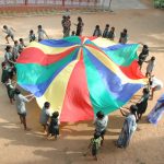 Children at Anbu Illam playing with a giant colour wheel